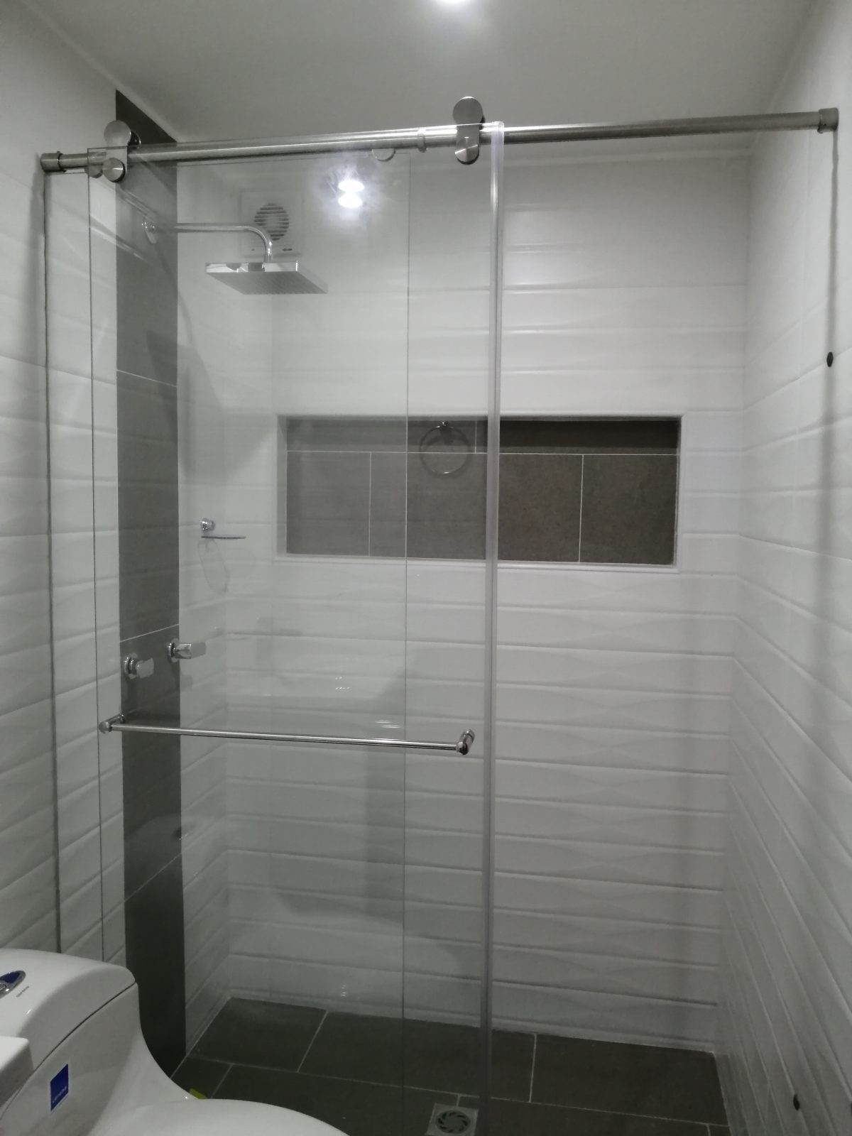 División de baño en sistema de corredera flotante con accesorios en acero inoxidable